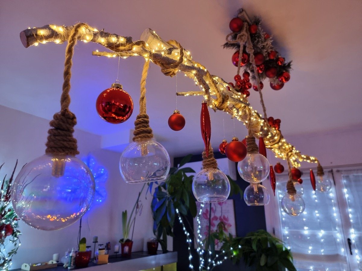Lustre du salon fabriqué à partir d’une branche lumineuse et de décorations suspendues