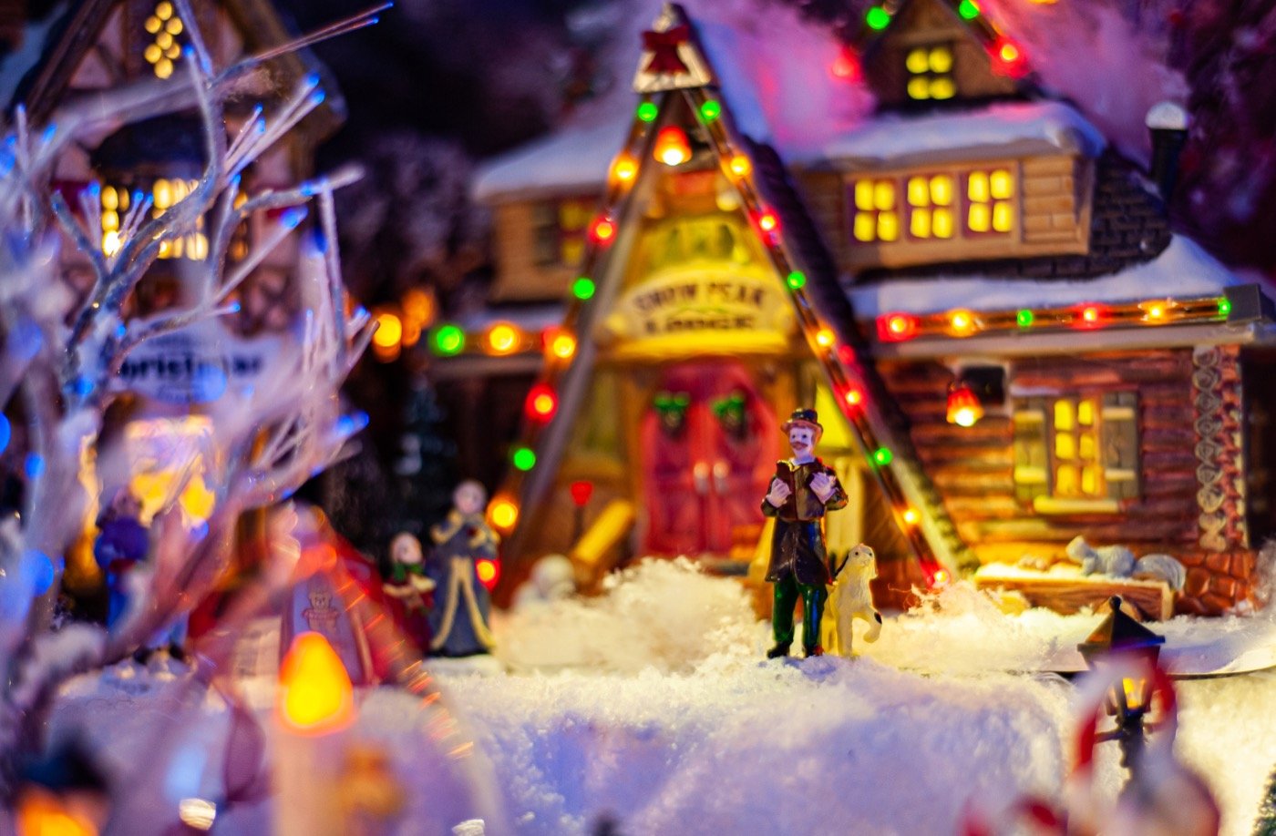 Chalet miniature illuminé et personnages dans la neige